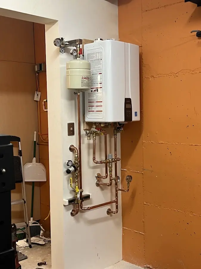 Plumbing technician inspecting water heater connections in Salmon